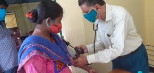 Asit Da performs a health check-up on a woman from one of the CRS health projects.